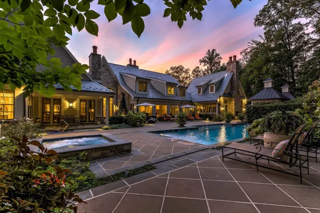 Stone home with pool at sunset