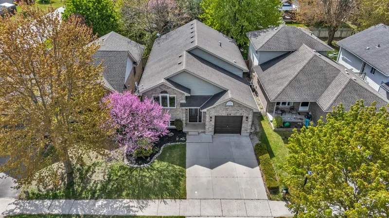 Aerial of a bungalow with a redbud in bloom — Strathroy real estate photography by Estate Shutter