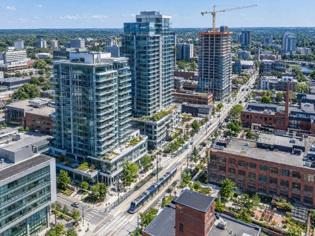 Aerial view of new towers and a light-rail line in Kitchener-Waterloo with a crane