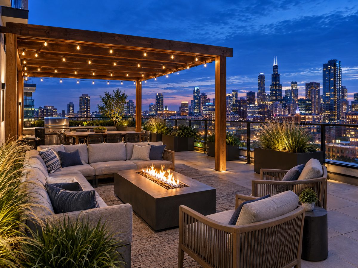 Condo rooftop amenity terrace with fire table and pergola at twilight