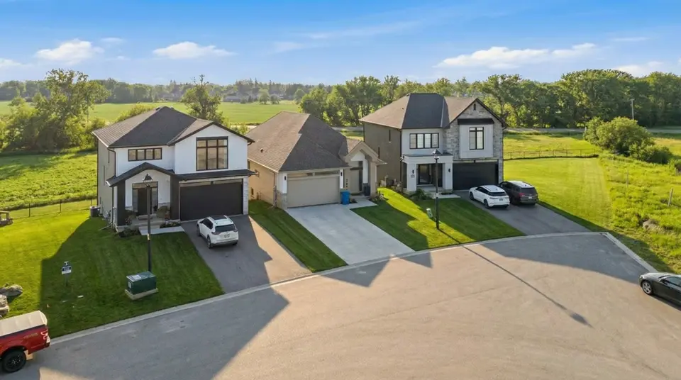 Aerial view of new two-storey homes on a cul-de-sac backing onto green fields
