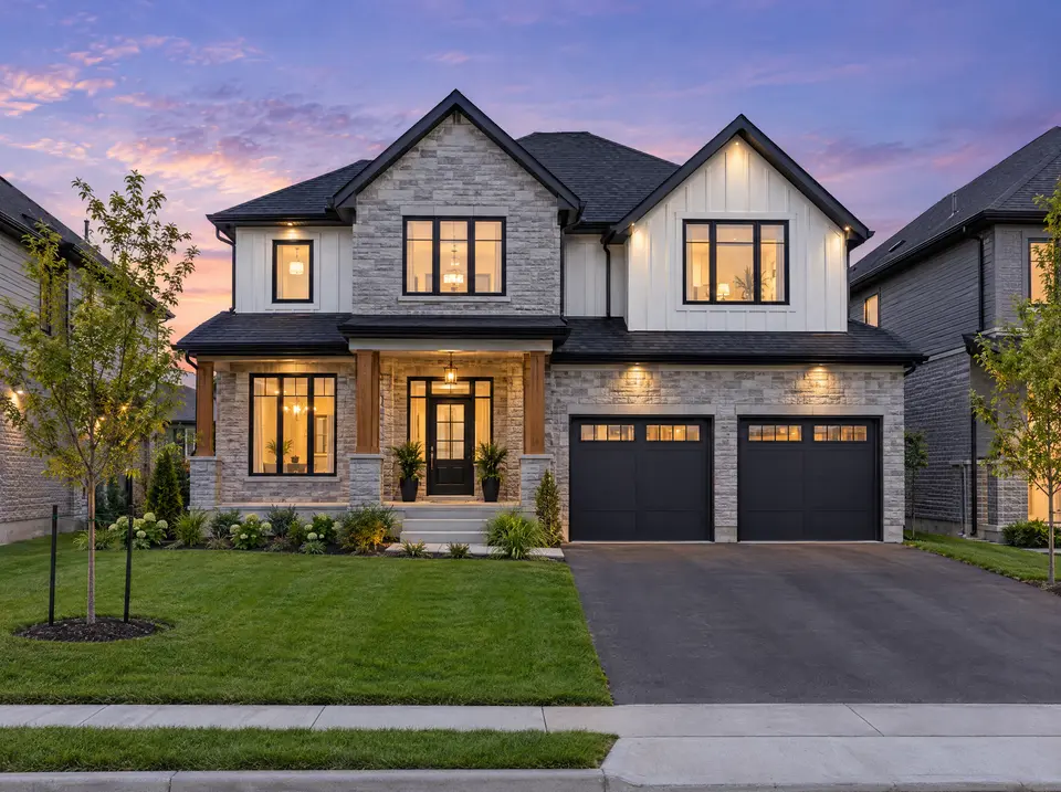 Stone and board-and-batten two-storey home with double garage under a purple twilight sky