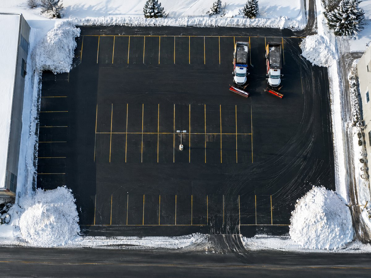 Top-down drone photo of a freshly plowed commercial parking lot after a storm