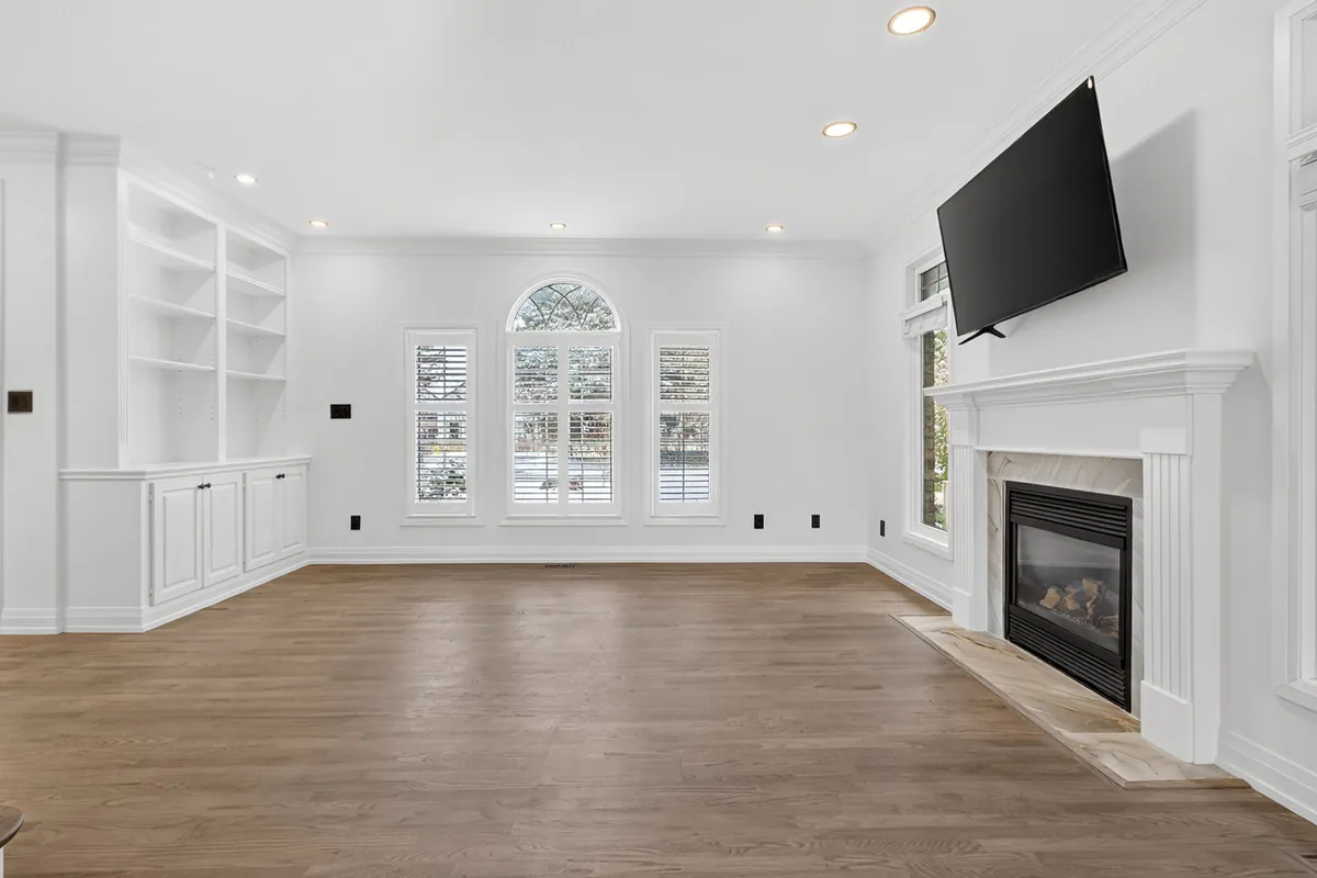 Empty London living room with a fireplace and built-in shelves