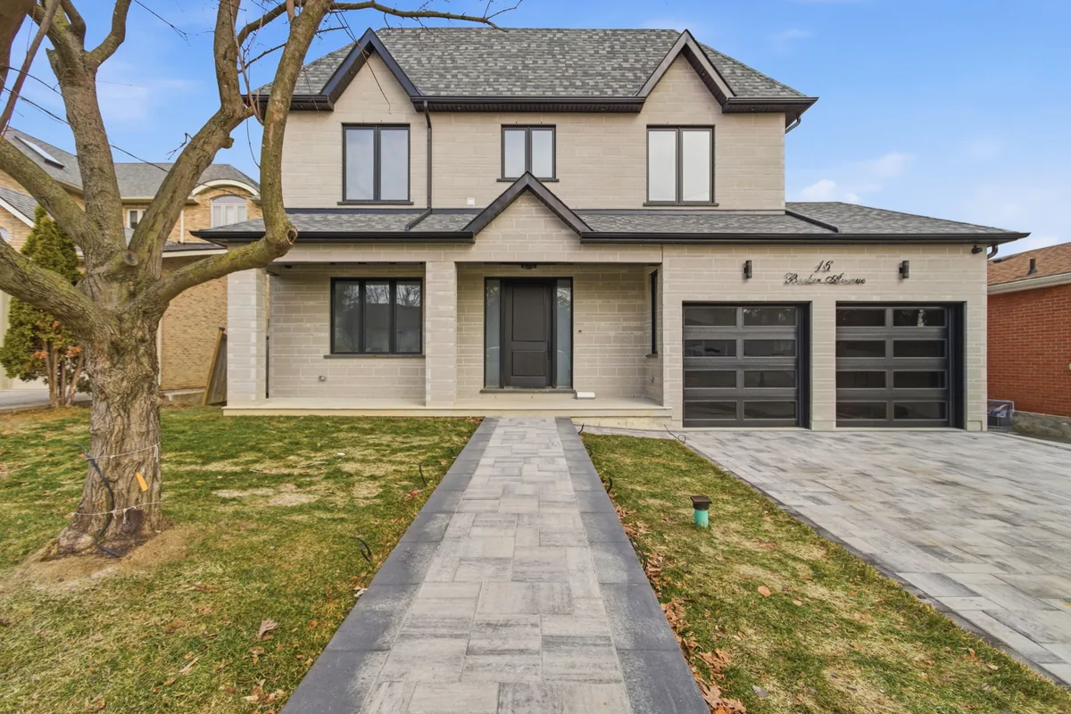 Two-storey brick home in Toronto with a stone walkway, in daylight