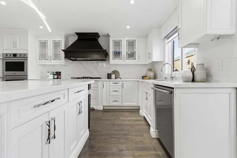 White kitchen with island and dark range hood — Mississauga real estate photography by Estate Shutter
